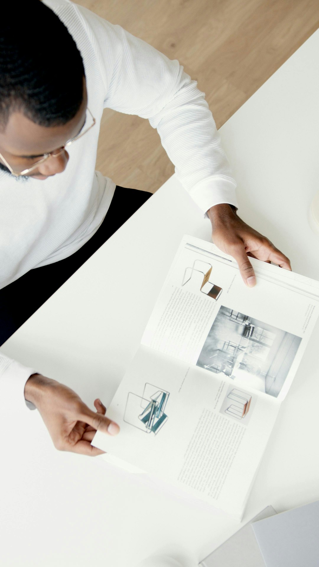 a-man-reads-a-magazine-at-a-white-table-1jk3-qzx4is
