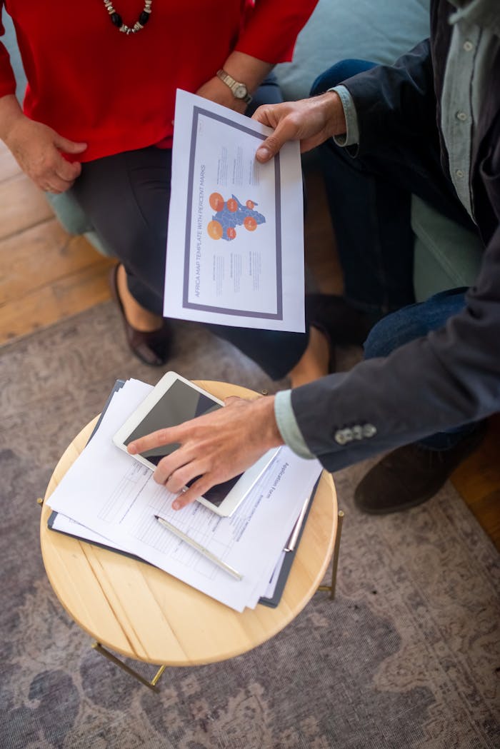 who-we-are Overhead view of a business meeting with documents and a tablet, showcasing collaboration.